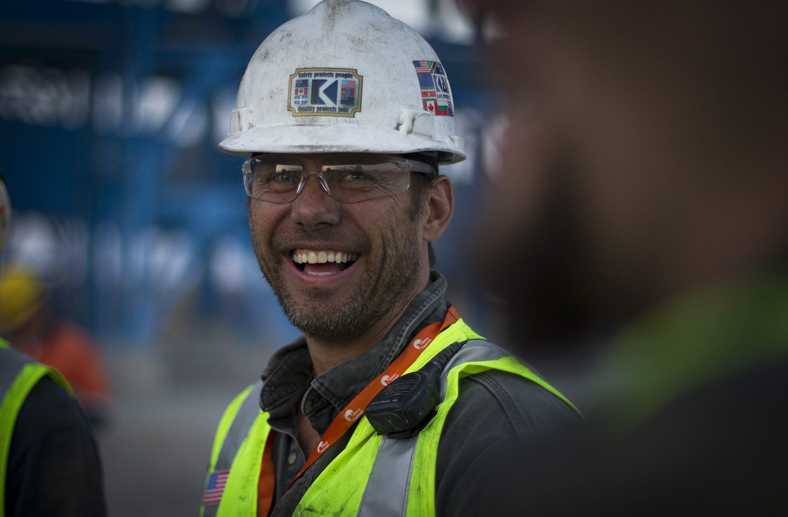A smiling Kaltech worker wearing a hardhat