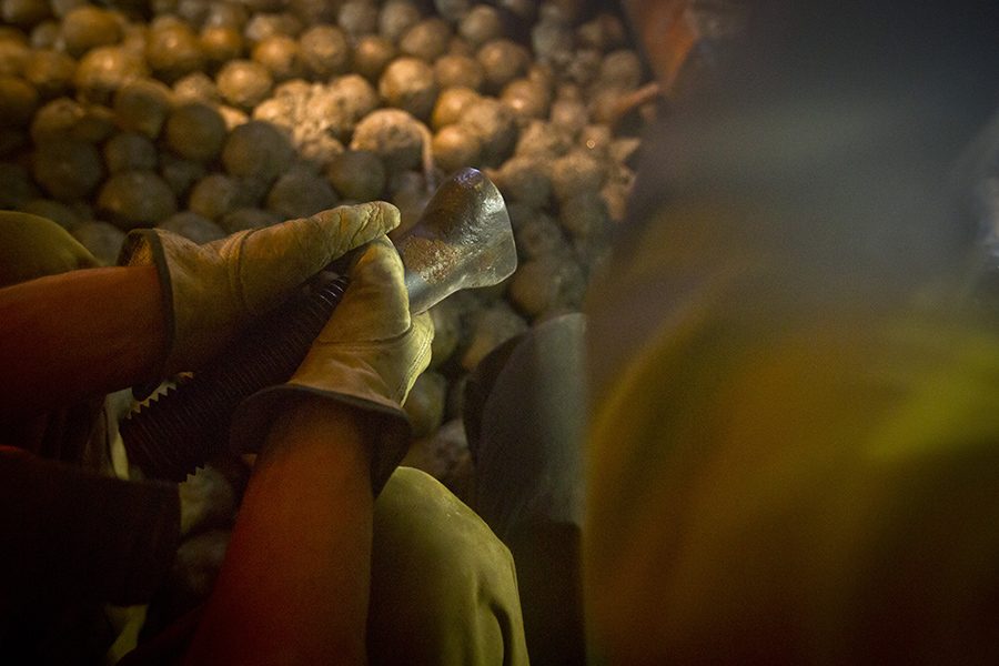 Hands of a Kaltech worker beside the ball charge inside a mill